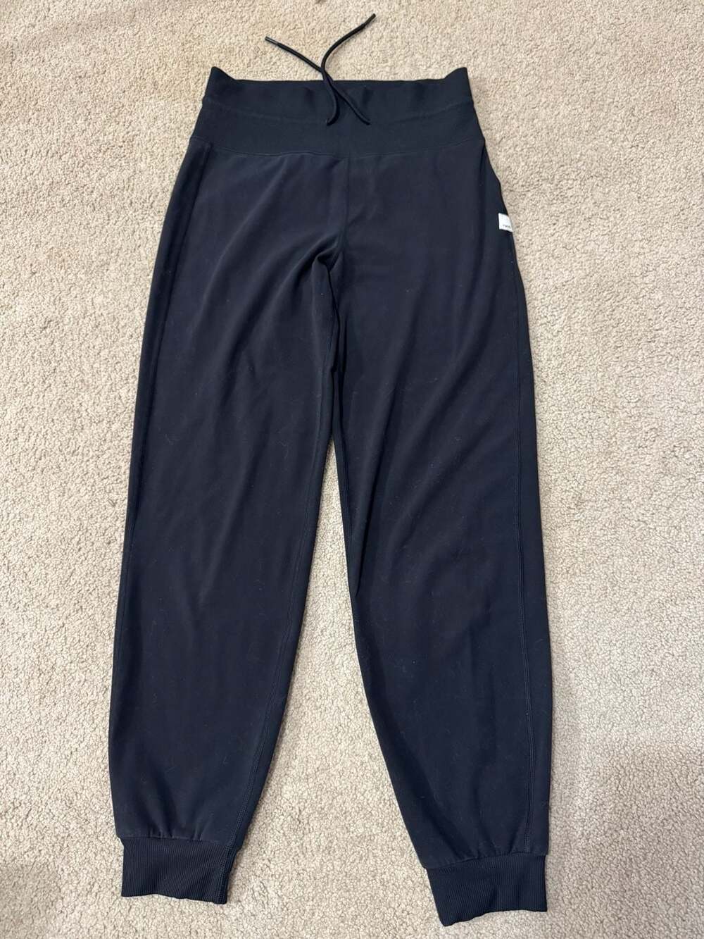 Vuori black high-waisted performance joggers with ribbed waistband and cuffs